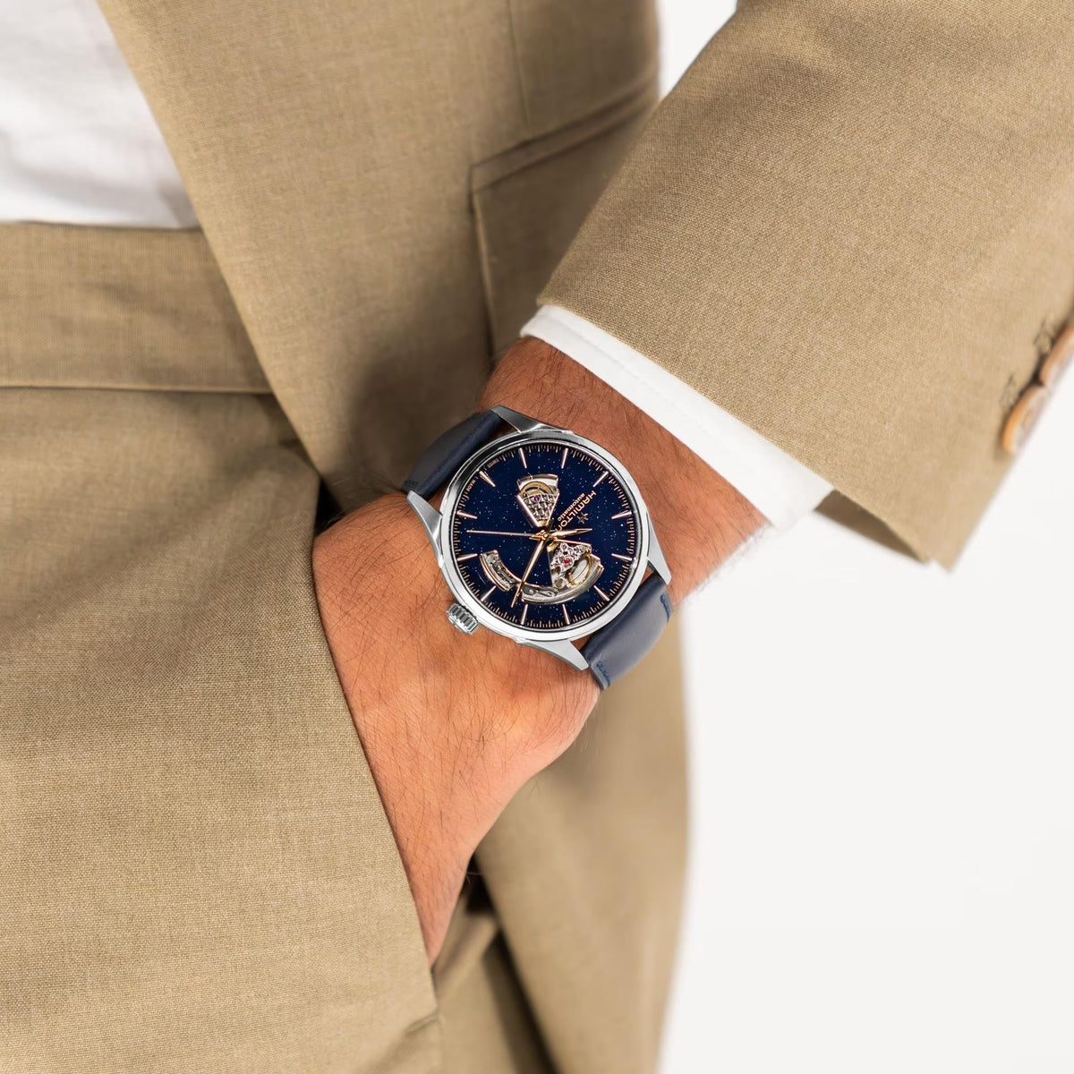 Hamilton Jazzmaster H32705640 open heart automatic watch wrist shot styled with tan suit sleeve and blue dial timepiece