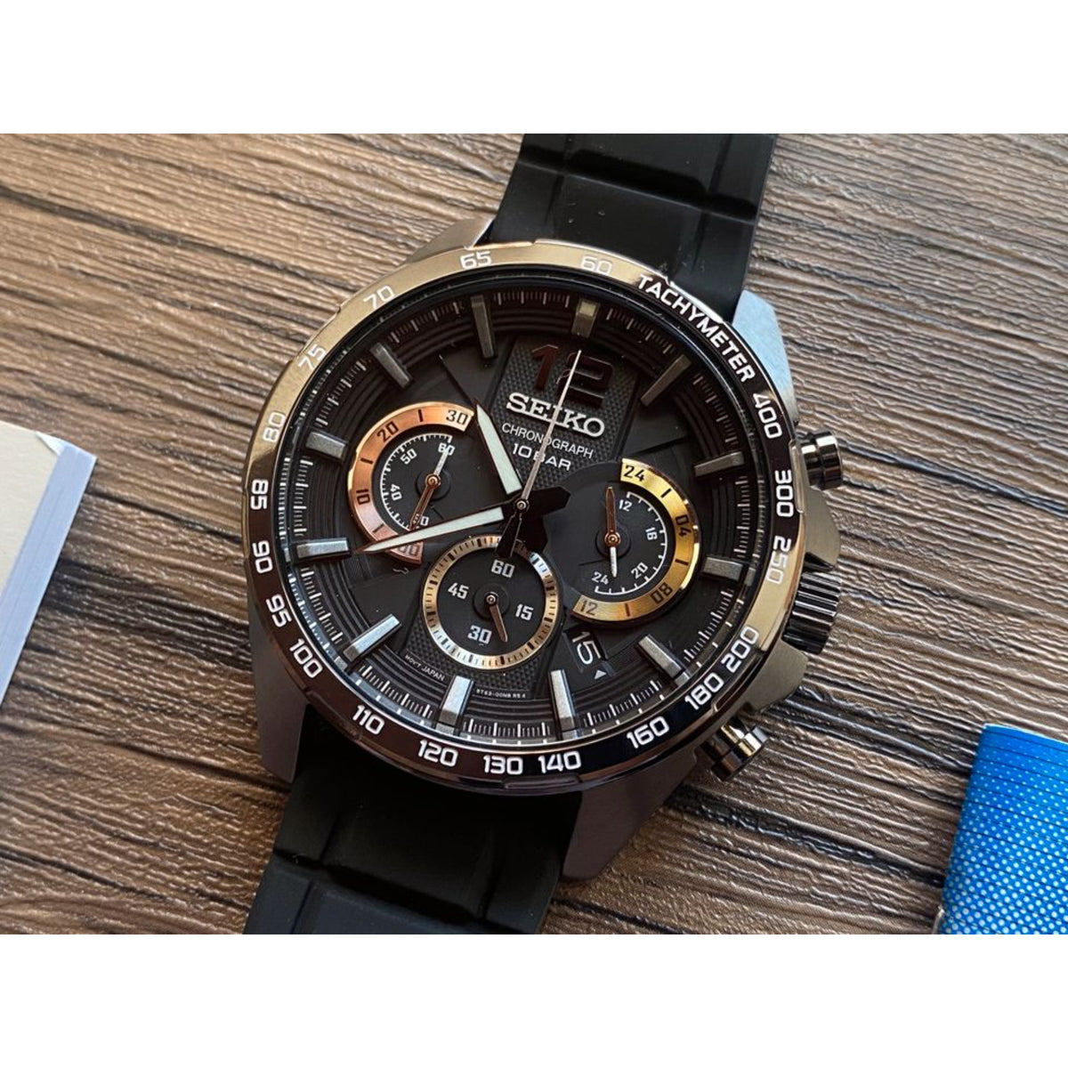 Seiko Essentials SSB349P1 watch with black and gold details on a wooden surface