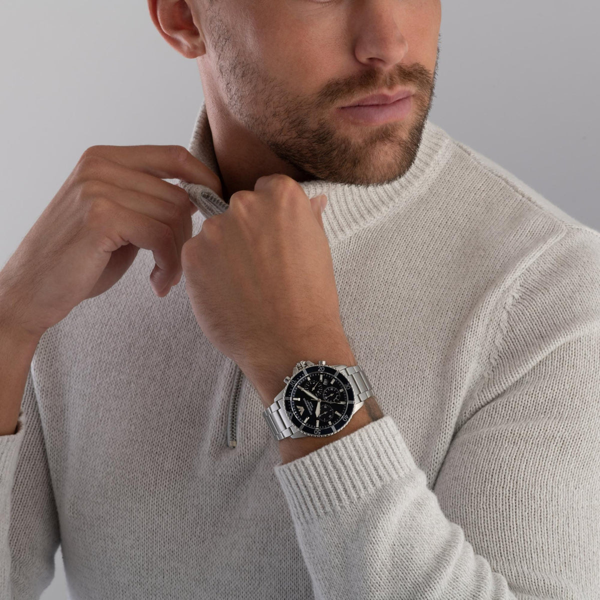 Model wearing the Emporio Armani World Explorer AR11681 wrist watch paired with a cream knitted jumper