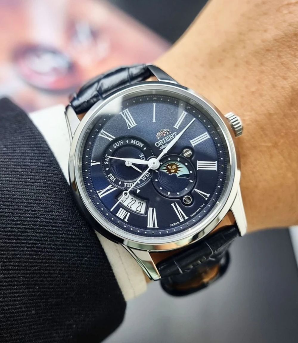 Orient Classic watch with sun and moon subdial complication on a wrist with a black suit cuff