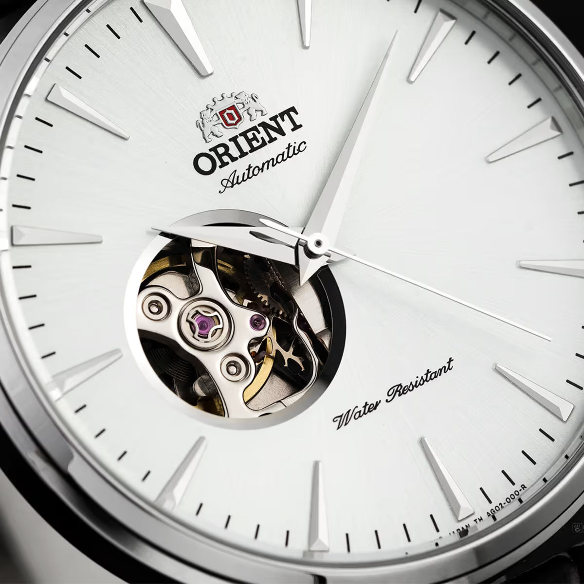 Orient automatic watch close-up with white open-heart dial and silver hands