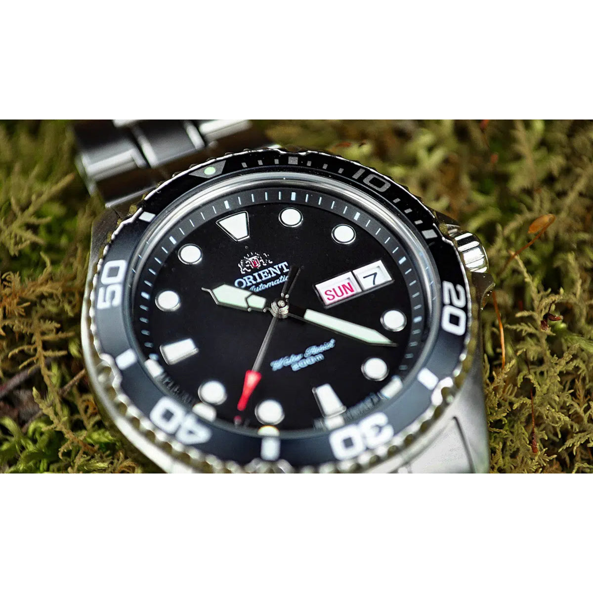 Men's automatic wristwatch close-up: black dial with day/date window marked SUN
