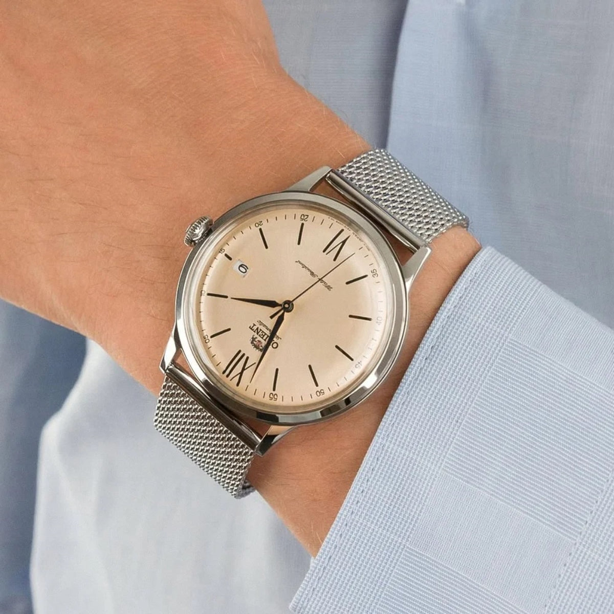 Men's automatic watch on wrist with champagne dial and silver mesh bracelet