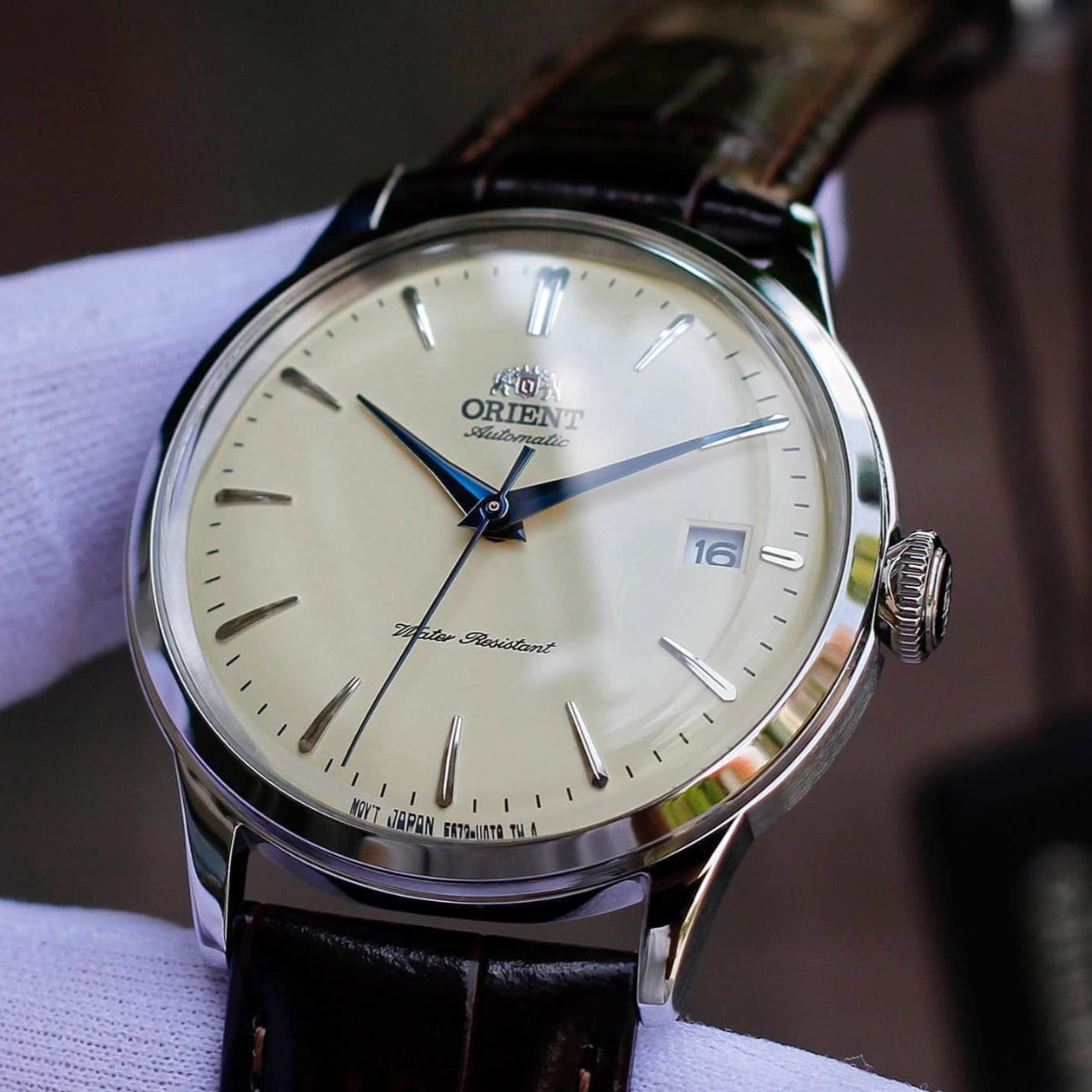 Orient Bambino RA-AC0M04Y30B mens automatic watch with champagne dial, blue hands, and leather strap