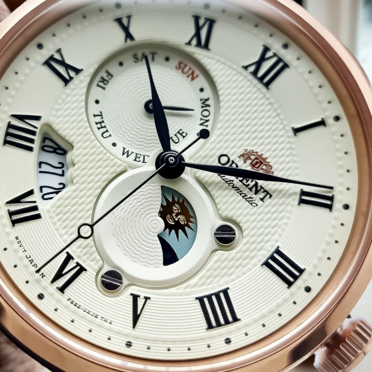 Closeup of Orient Bambino Sun & Moon RA-AK0007S30B mens watch highlighting the champagne dial, day/night subdial, and Roman numerals