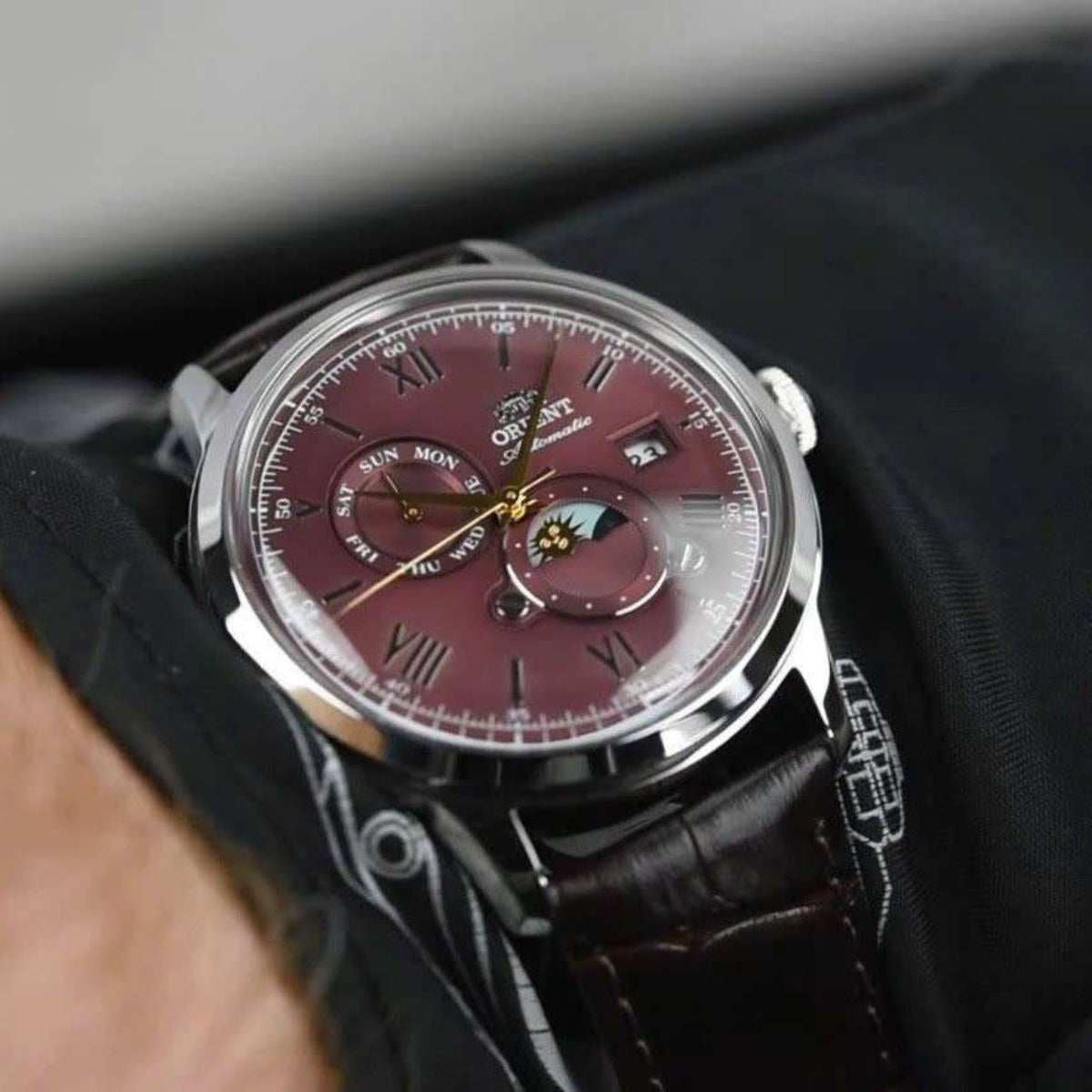 Orient Bambino RA-AK0807R30B red sun-and-moon dial automatic watch with brown leather strap and stainless steel case