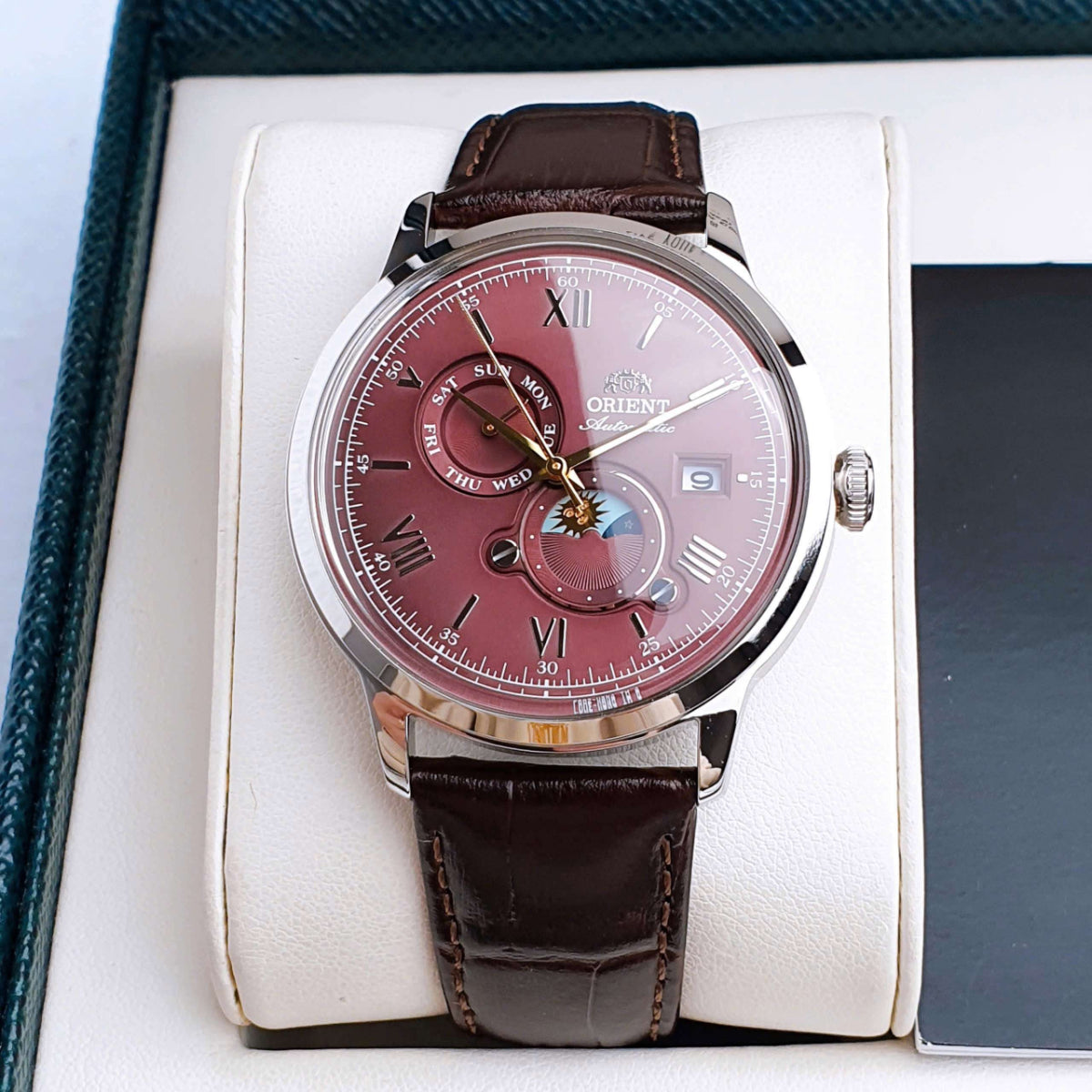 Orient Bambino RA-AK0807R30B mens automatic wrist watch with red dial, sun-moon subdials, brown leather strap