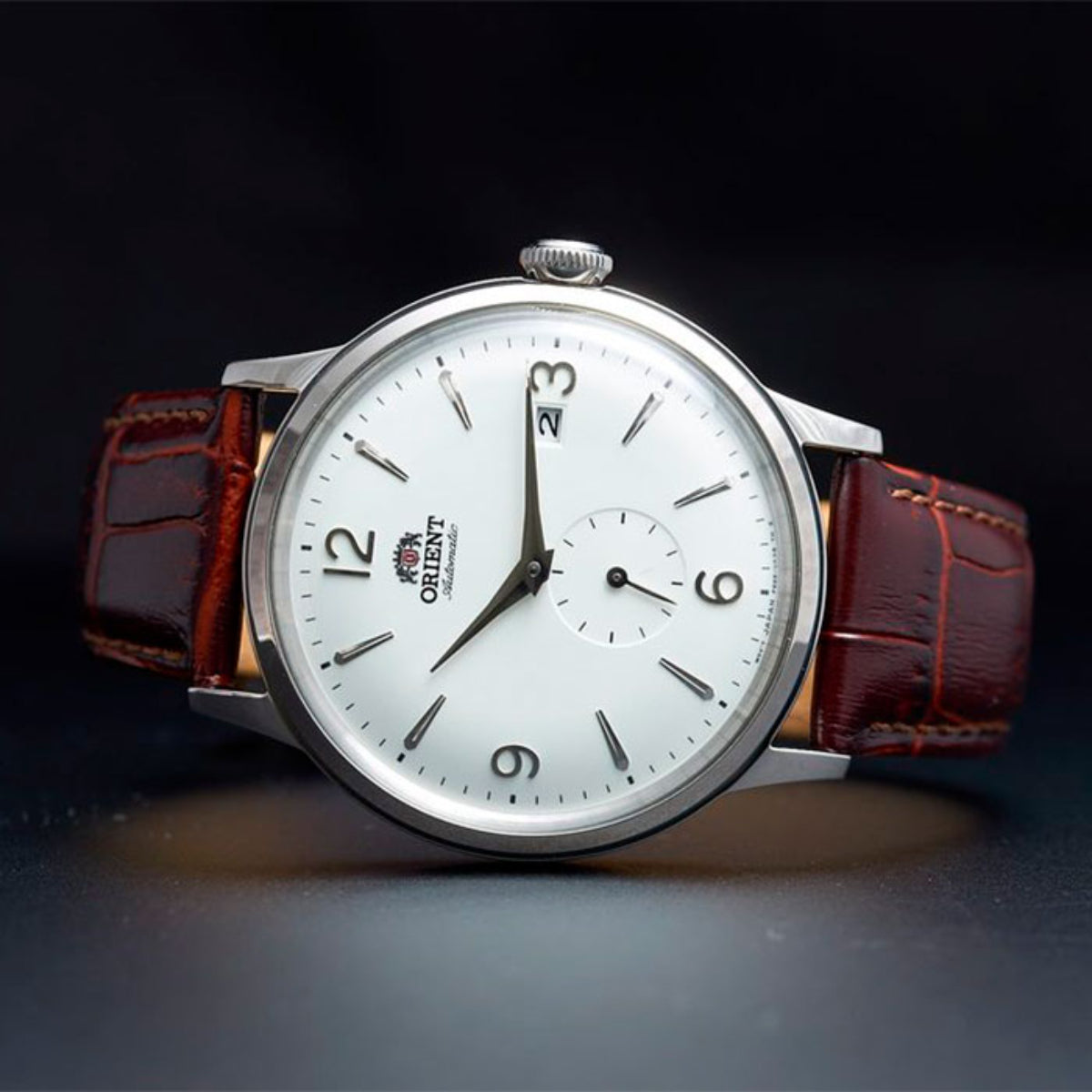 Men's automatic watch with white dial, brown leather strap, and silver round bezel