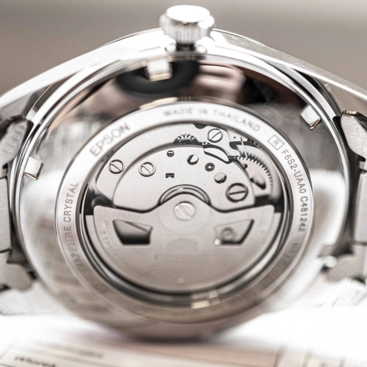 Open-heart automatic watch case back close-up with engraved design and mechanism