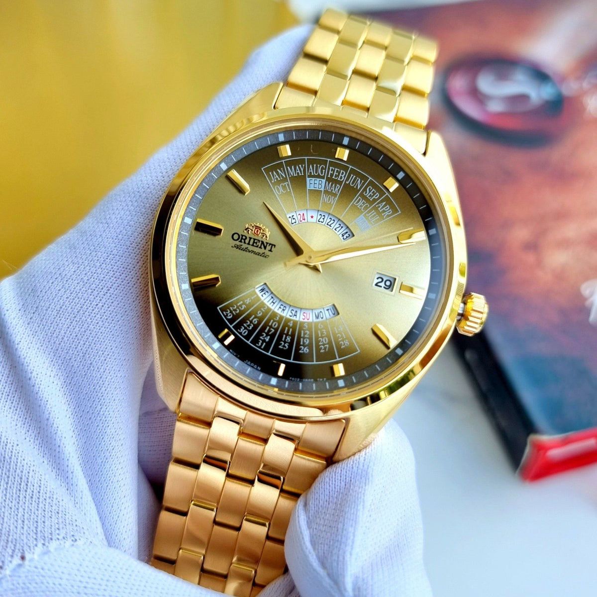 Orient Multi-Year Calendar RA-BA0001G30B automatic watch on wrist, gold-tone bracelet, and light gradient dial with date window
