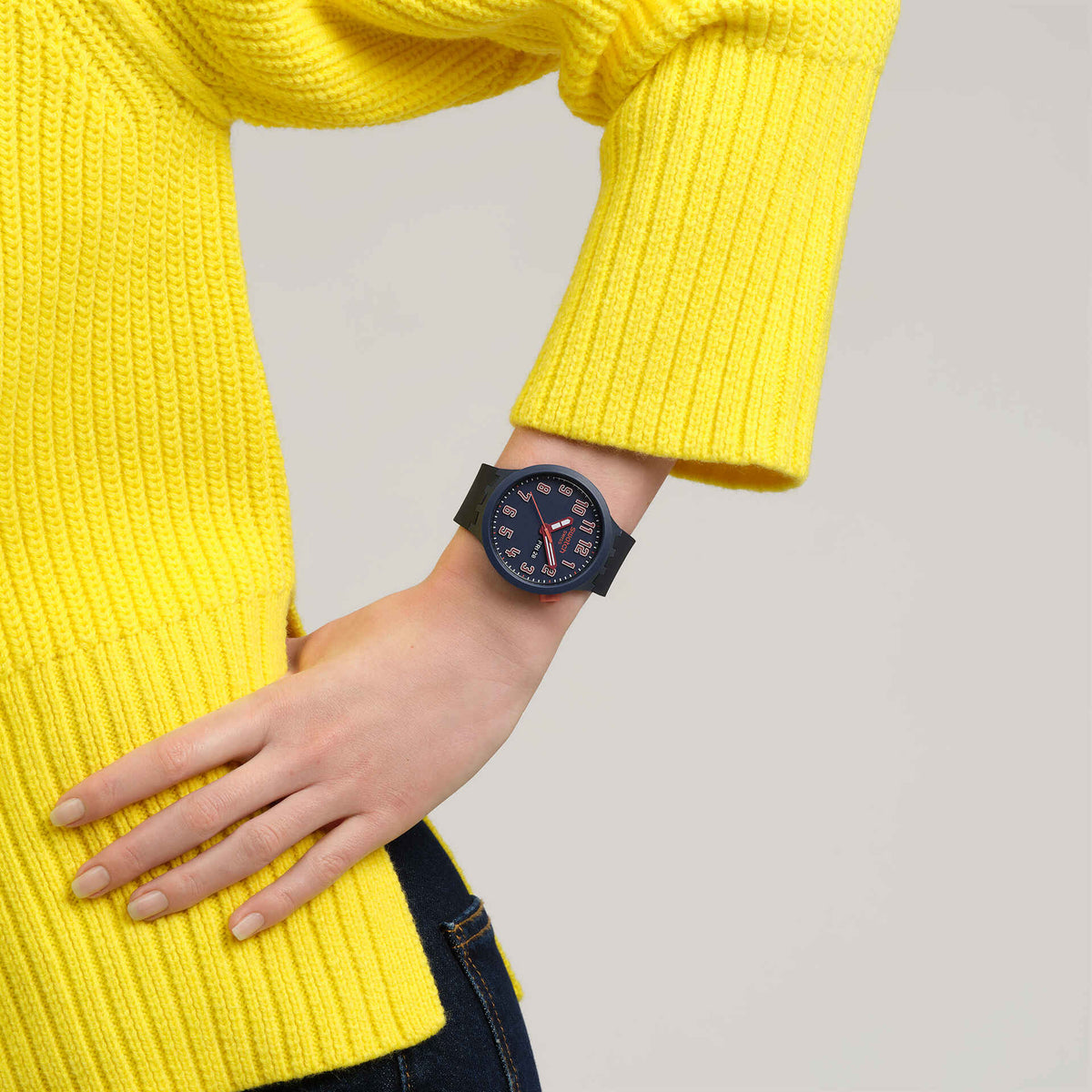 Dark blue silicone strap watch on wrist, dark blue dial with orange hands and numbers