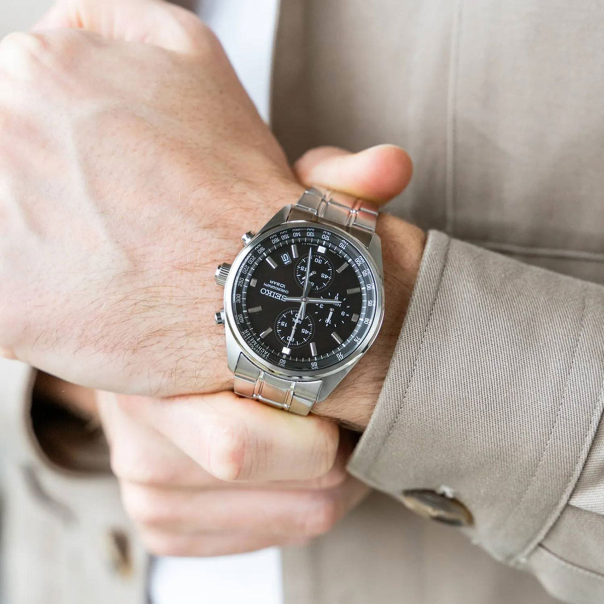 Close-up of a person wearing Seiko Essentials SSB379P silver watch with a black dial and stainless steel bracelet