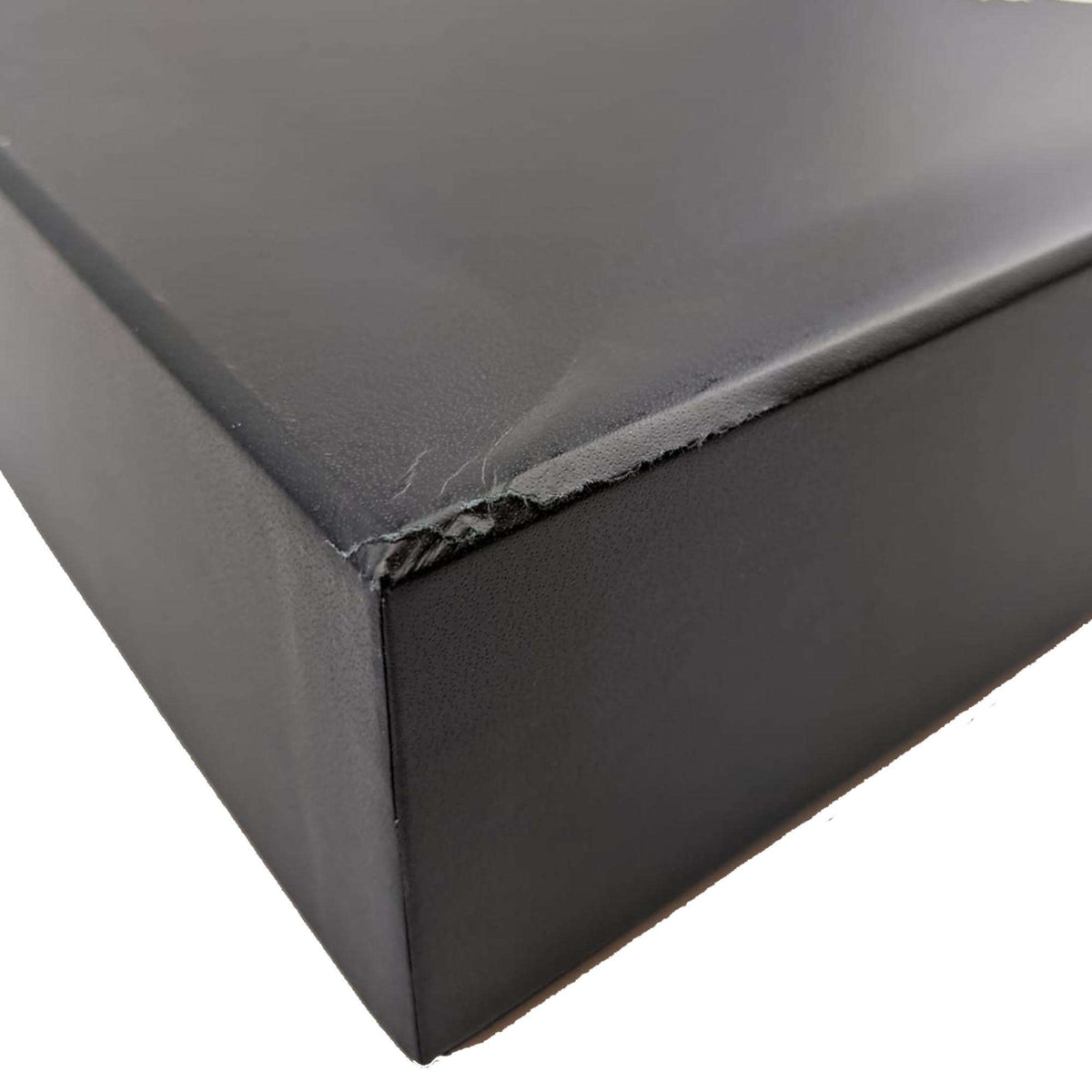 Black watch box corner with visible damage and frayed seam