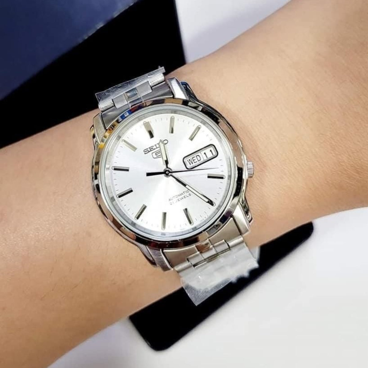 Men's automatic watch on wrist, silver dial with day/date window and stainless bracelet