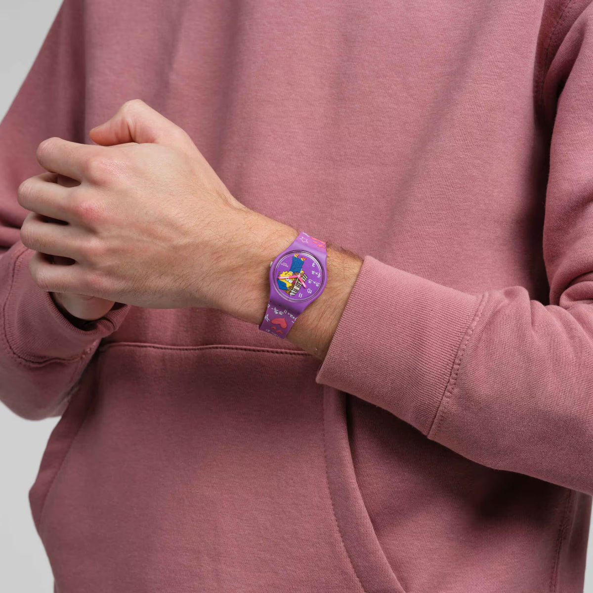 Purple Swatch watch worn on arm with Lisa-dial and purple silicone strap hearts detail