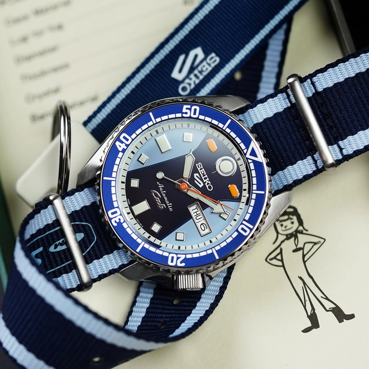 Blue dial automatic diver watch on blue-and-white NATO strap