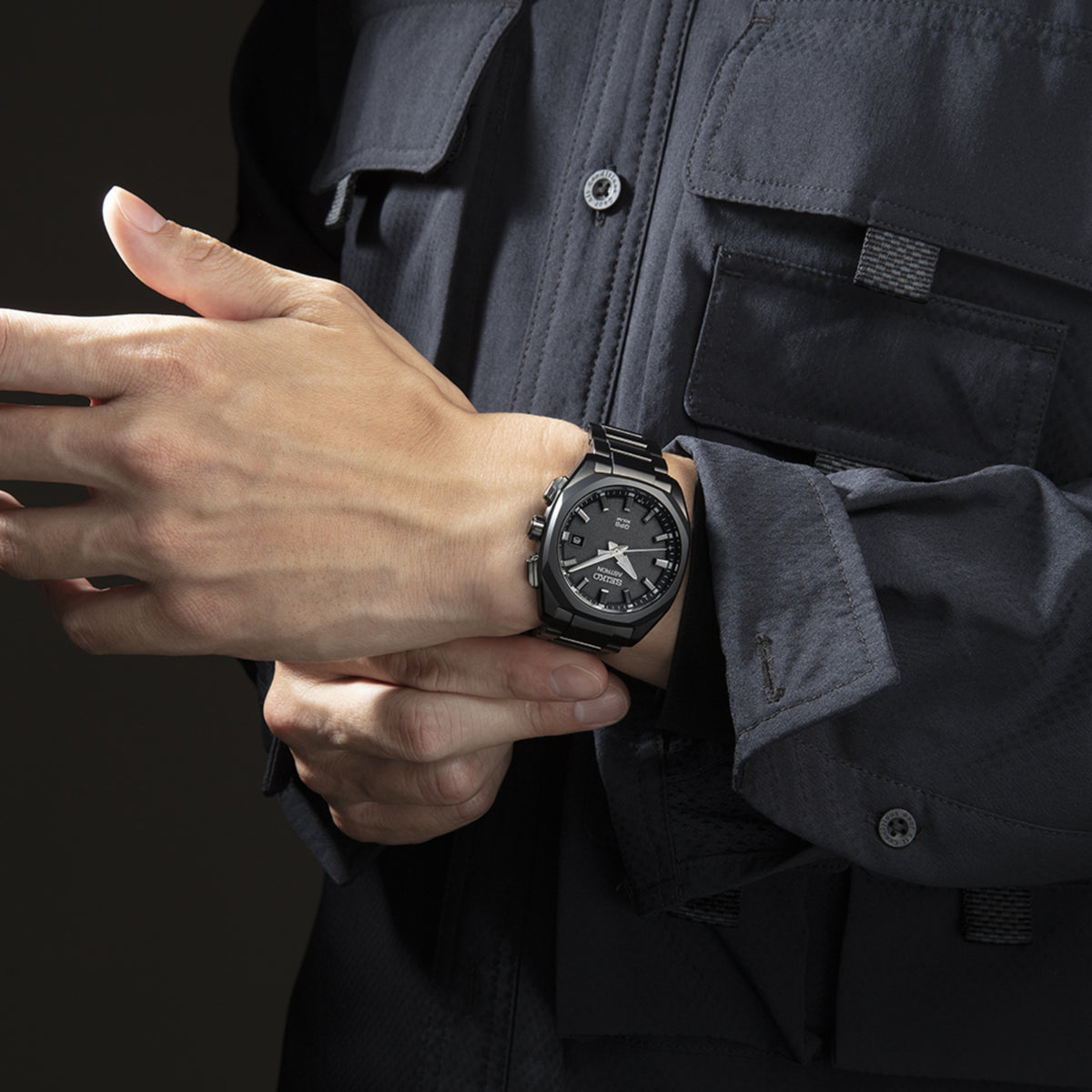 Men's black GPS solar watch on wrist, round case with textured dial and bracelet