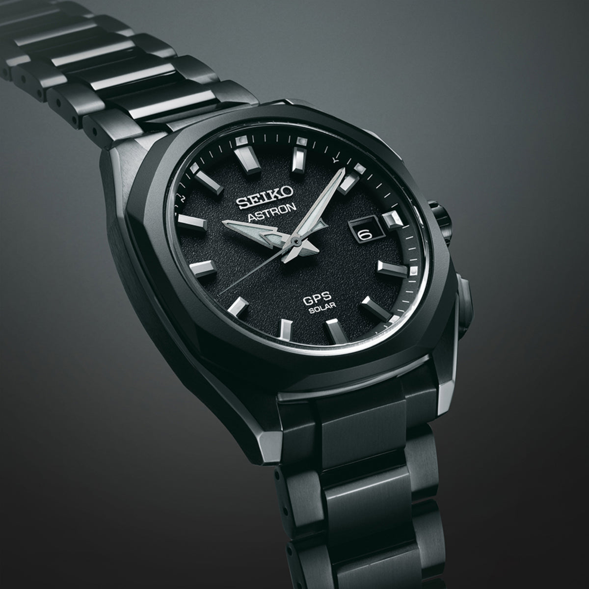 Black men's GPS solar watch, angled view of textured dial and metal bracelet