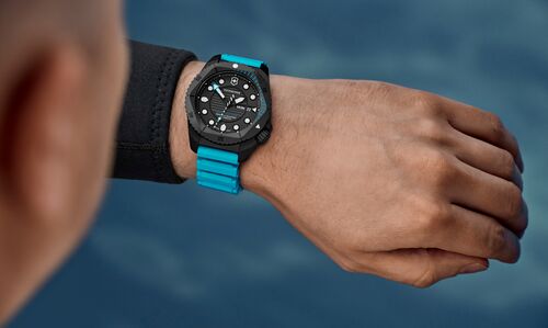 Diver wearing Victorinox I.N.O.X. Dive Pro watch with bright cyan blue rubber strap