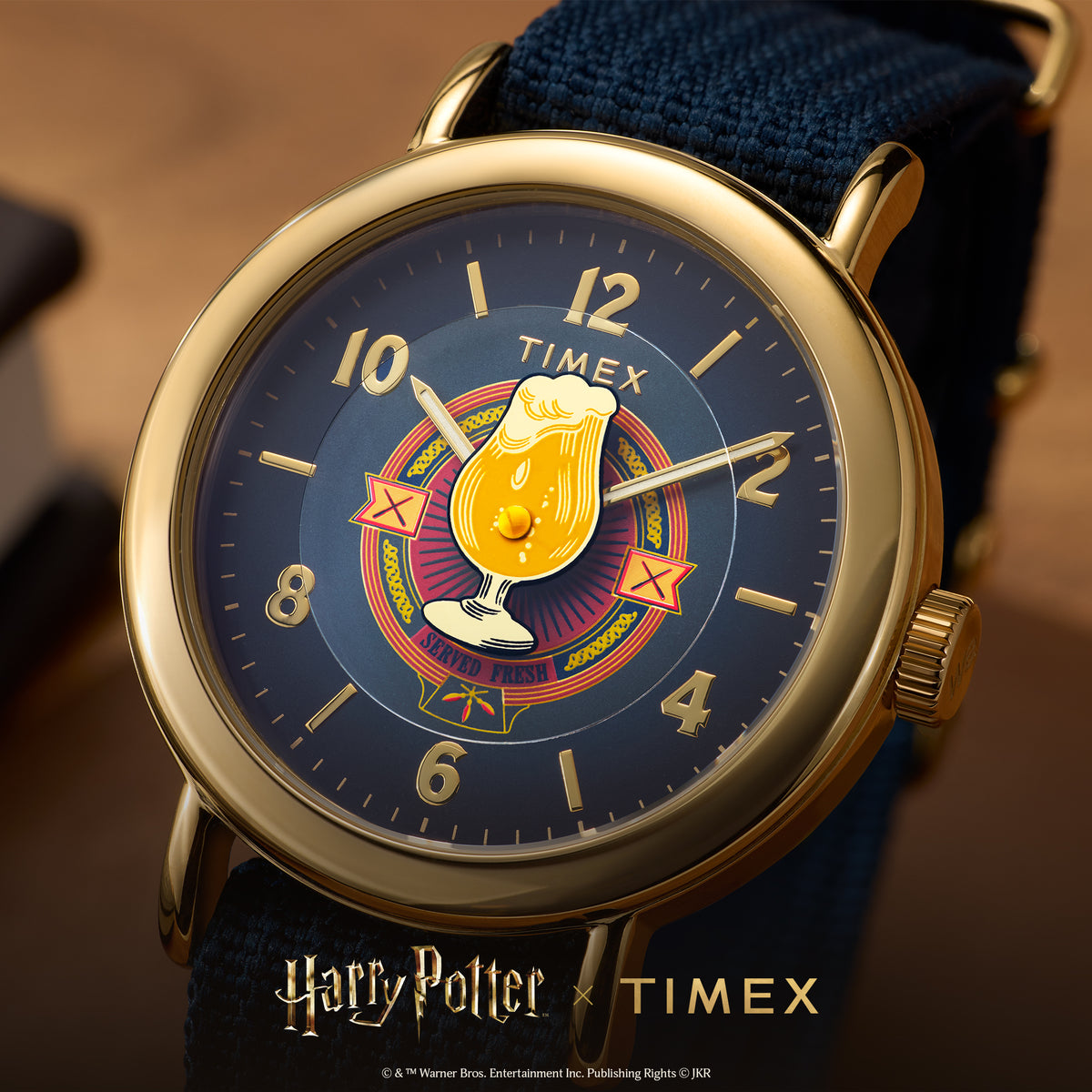 Gold-tone round quartz watch with blue dial and blue fabric strap