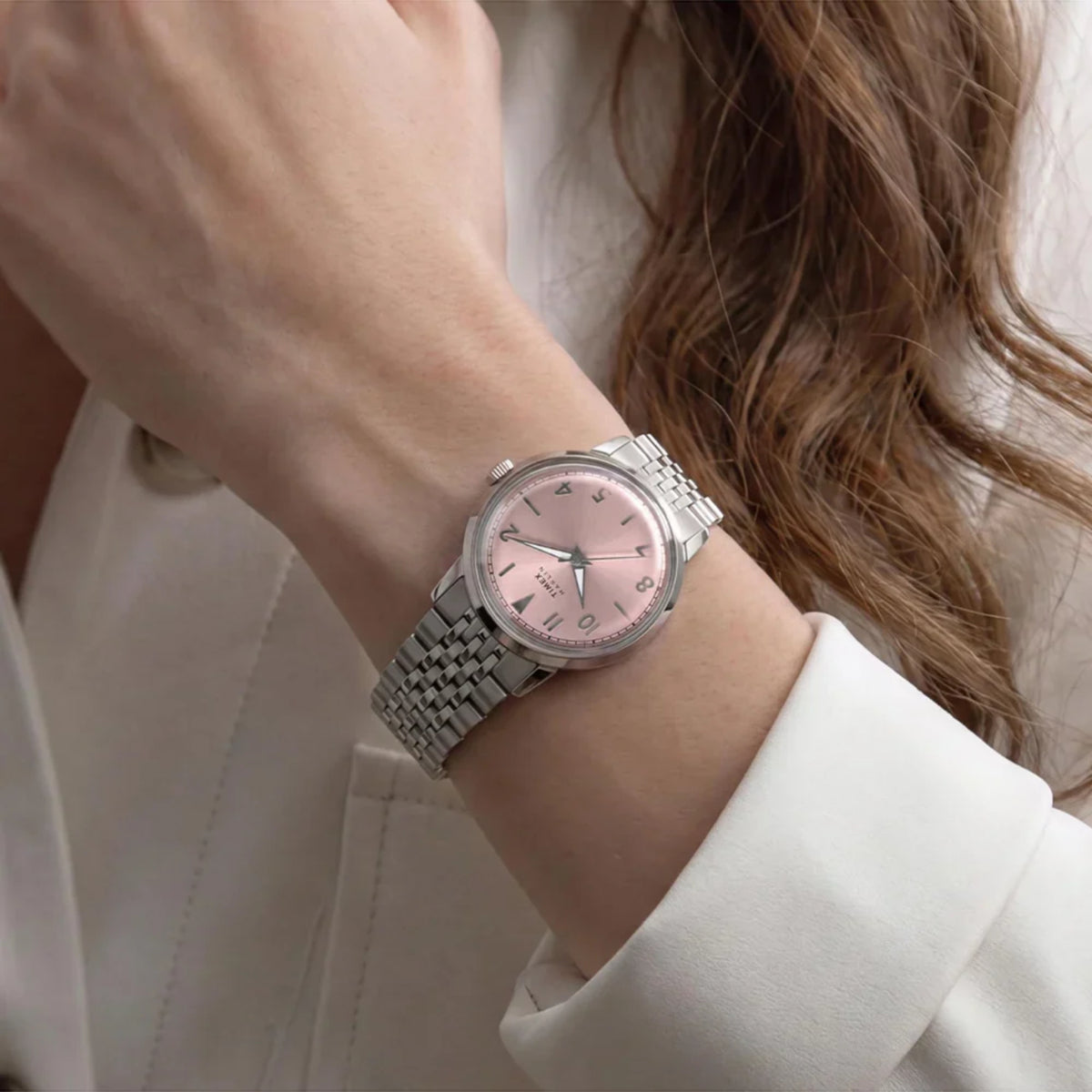 Timex Marlin TW6A03900 wrist view showing a pink dial quartz watch styled on a person wearing a steel link bracelet