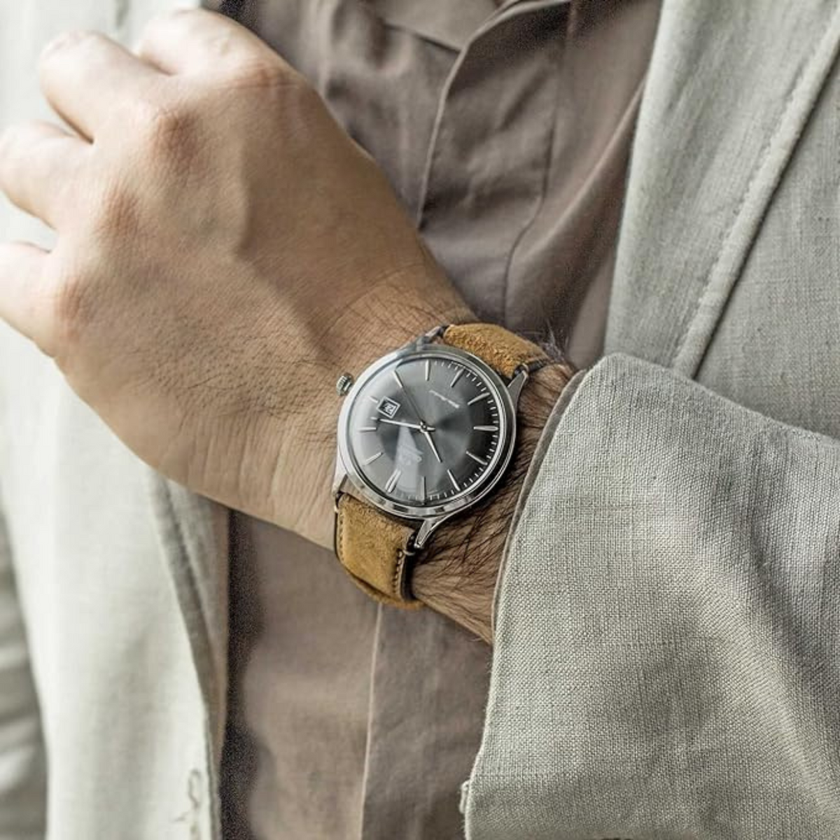 Mens automatic watch on wrist with dark grey dial and tan-brown leather strap