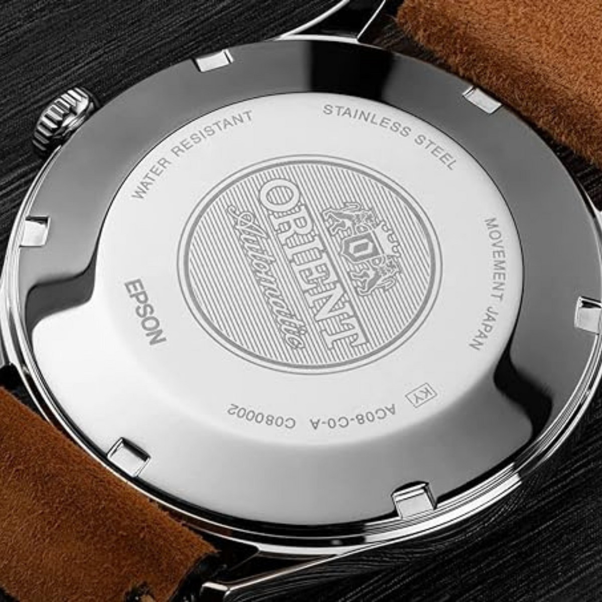 Stainless steel watch caseback with engraved pattern, brown leather strap