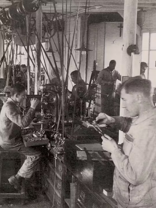 Vintage archival photo of Swiss craftsmen manufacturing Victorinox products in original factory workshop