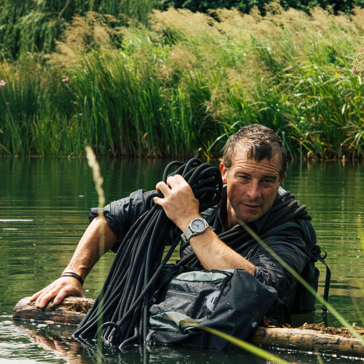 Bear Grylls wading through water, holding a heavy rope, wearing his Luminox Bear Grylls Survival XB.3717 adventure watch