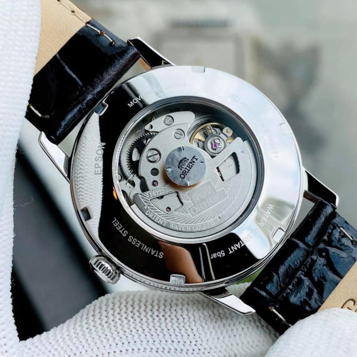 Orient automatic watch case back view with open mechanism through transparent cover