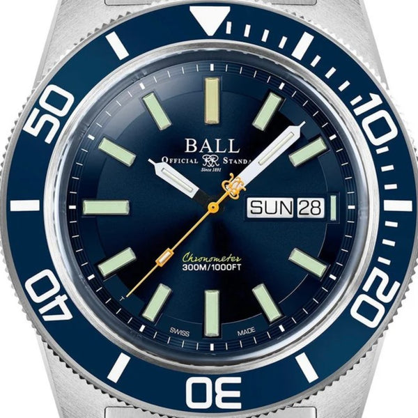 Close-up of blue dial diver watch with silver bezel, gold hands, and SUN 28 window