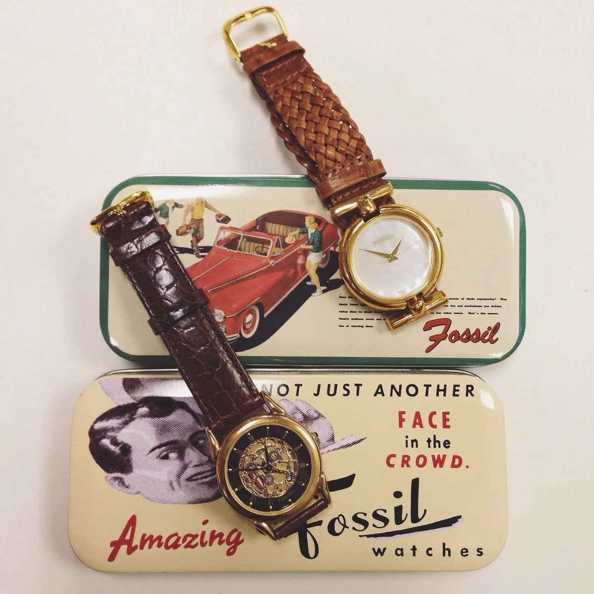 Fossil Heritage vintage-style womens and mens watches presented on collectible tin boxes featuring woven and alligator-grain leather straps