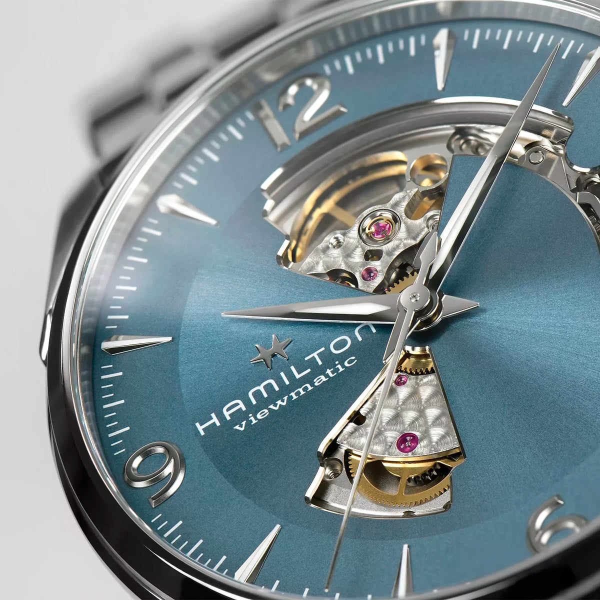 Men's automatic watch with open-heart blue dial and visible gold-toned movement