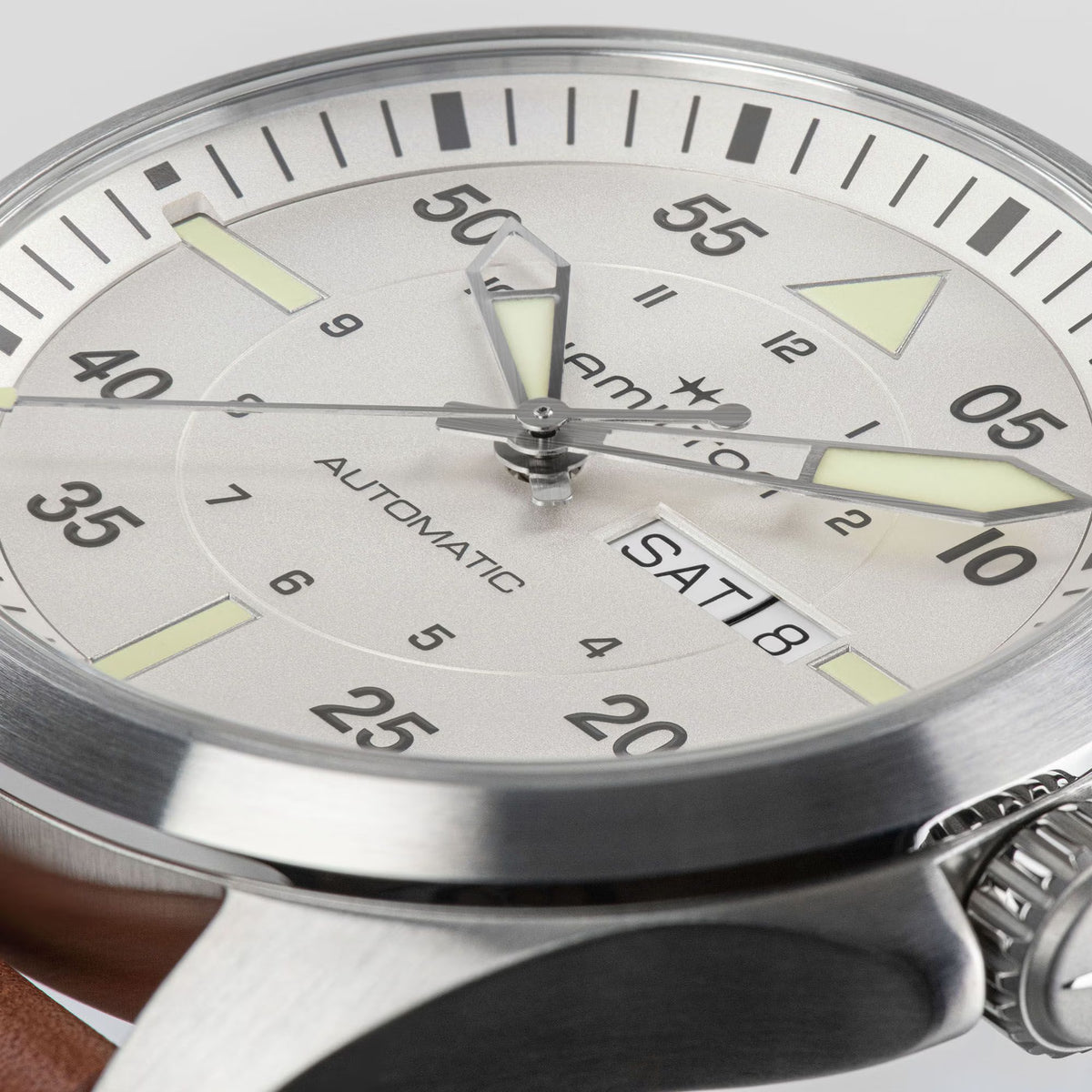Close-up of a Hamilton automatic watch with a silver dial and showing the day-date display
