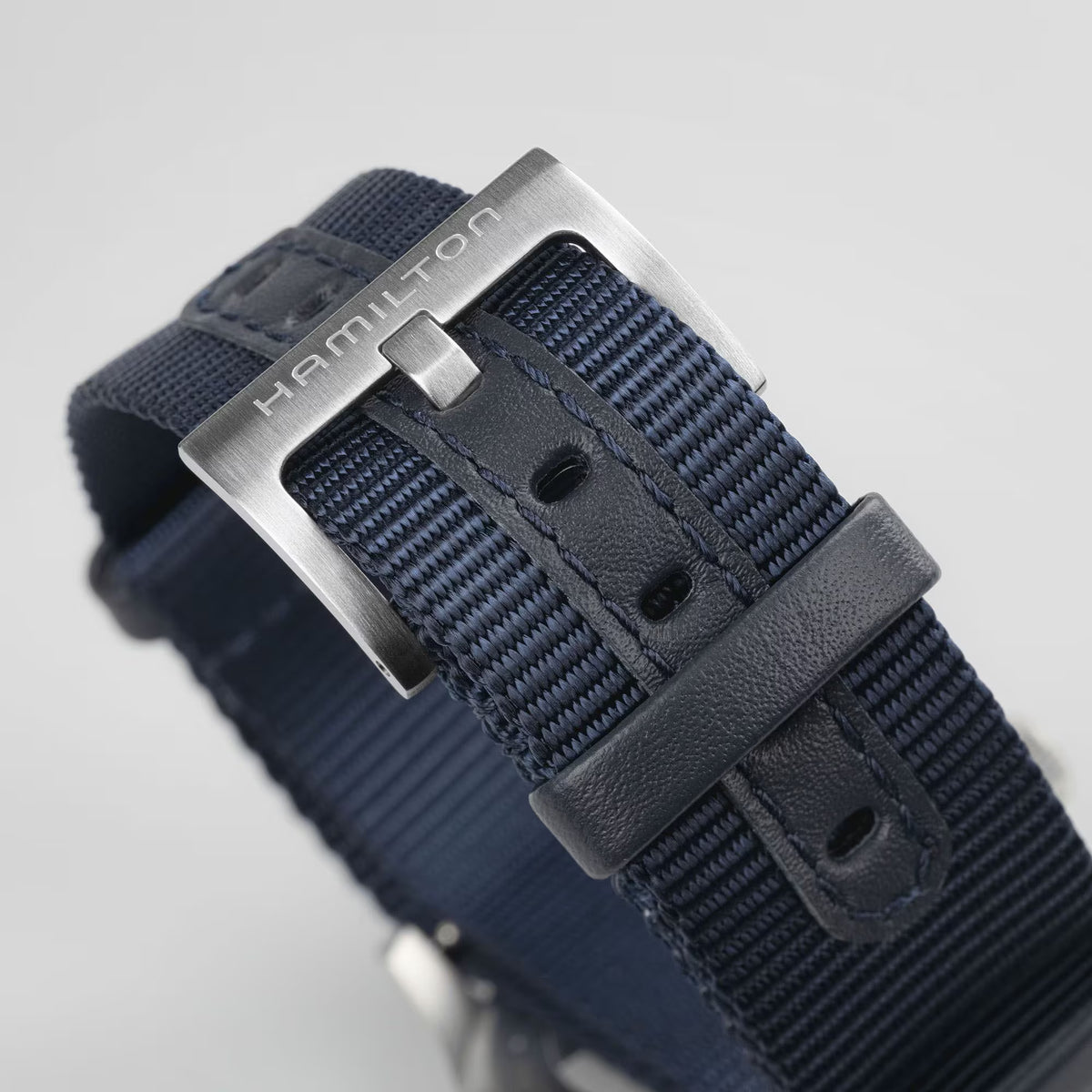 Close-up of Hamilton Khaki Field H69439940 brushed pin buckle and blue NATO strap with leather accents
