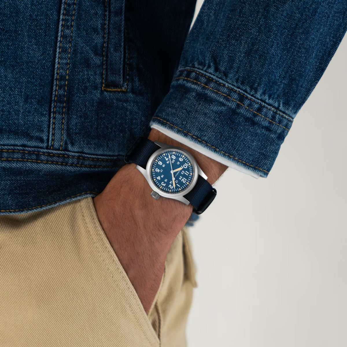 Hamilton Khaki Field H69439940 blue dial watch worn on wrist with denim jacket and beige trousers