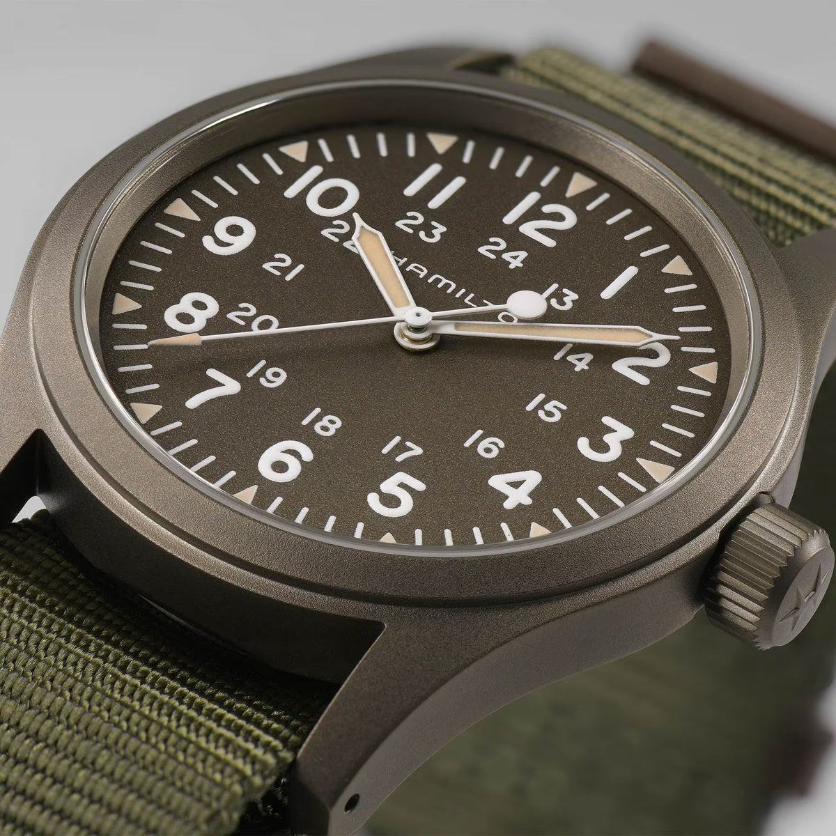 Men's field watch with green dial, olive NATO strap, round dark case, crown