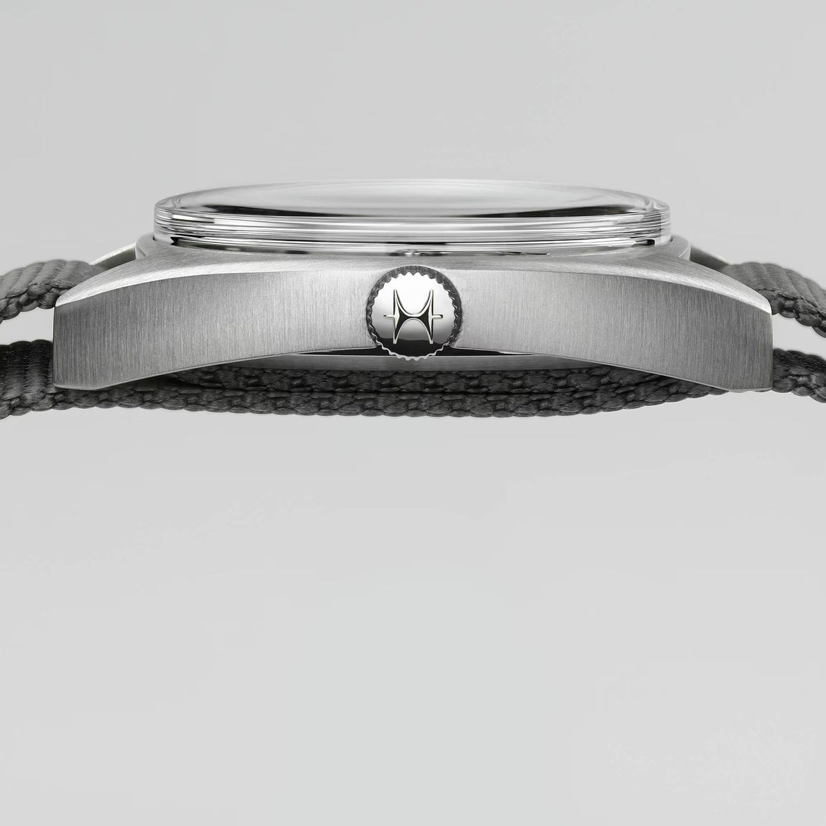 Hamilton stainless steel watch case back with model emblem on dark woven strap