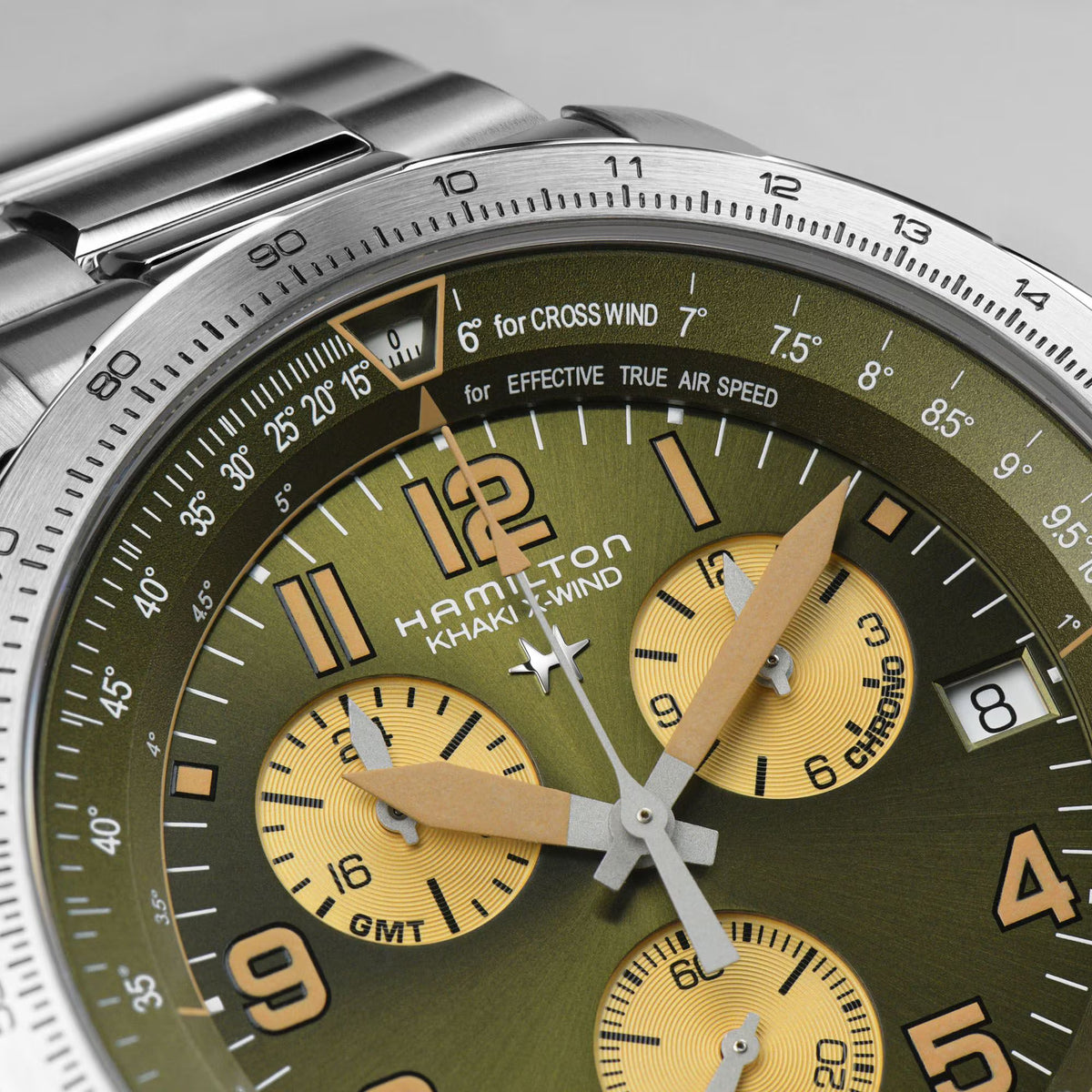 Close-up green dial chronograph watch with gold subdials and stainless bezel