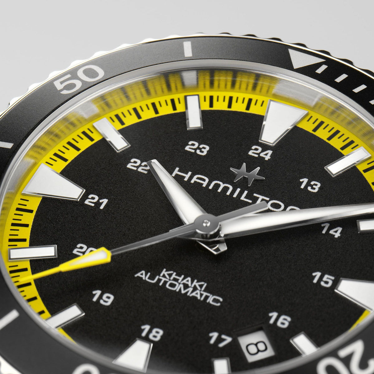Hamilton close-up: black dial with yellow minute track, silver hands and hour markers