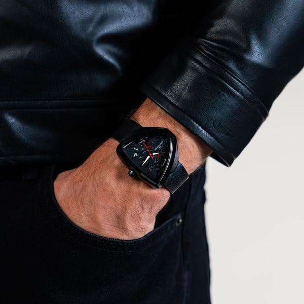 Men's wrist watch with black rubber strap and black skeleton dial, red second hand
