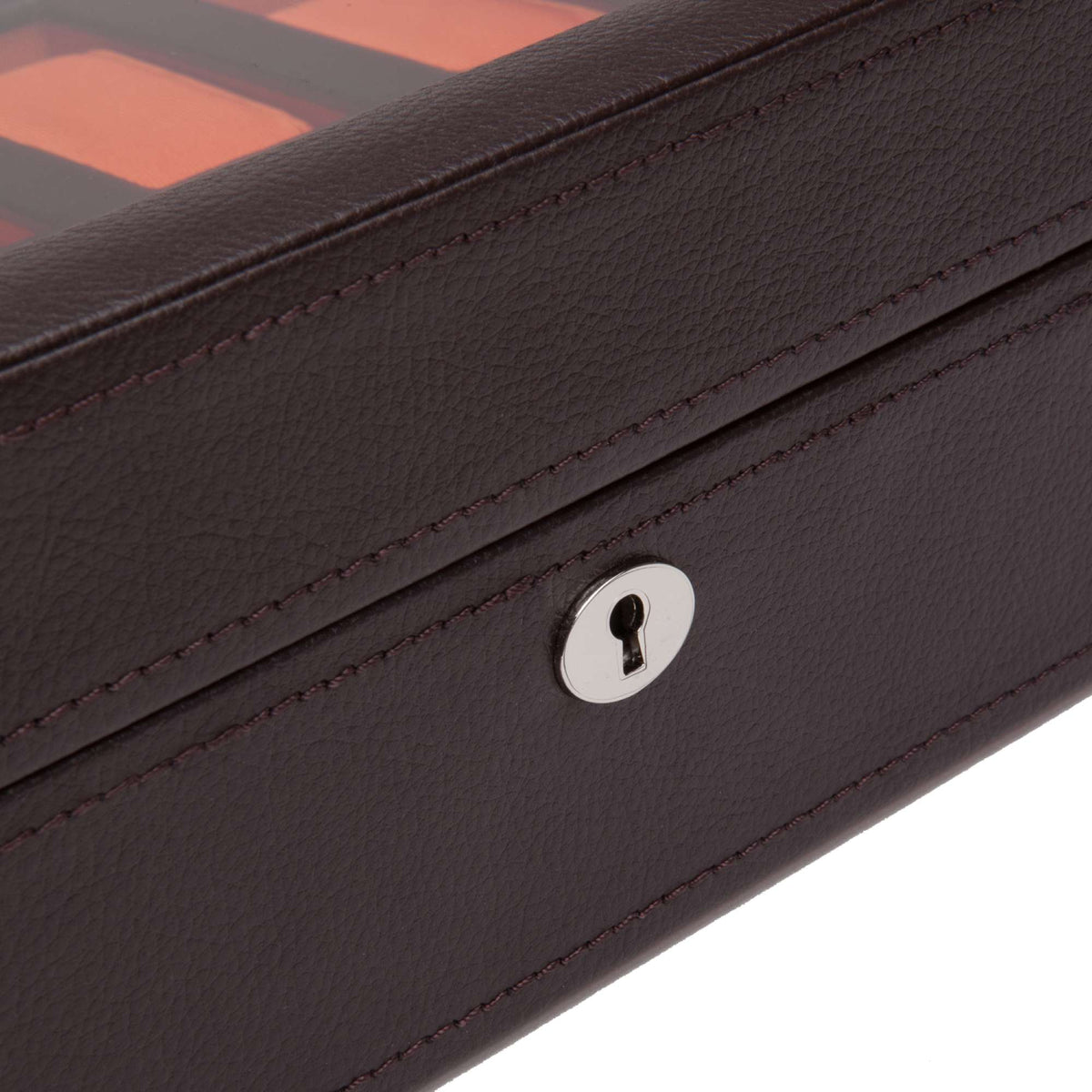 Brown watch storage box close-up: silver key lock and red stitching on textured cover