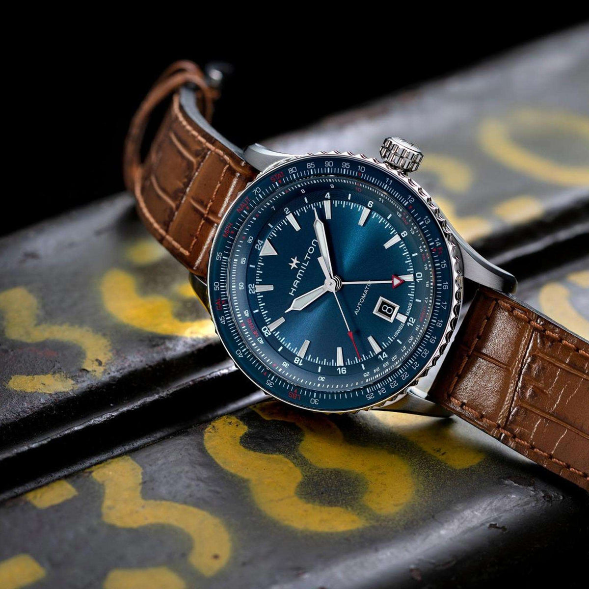 Mens automatic GMT watch with blue dial, red seconds hand, brown leather strap