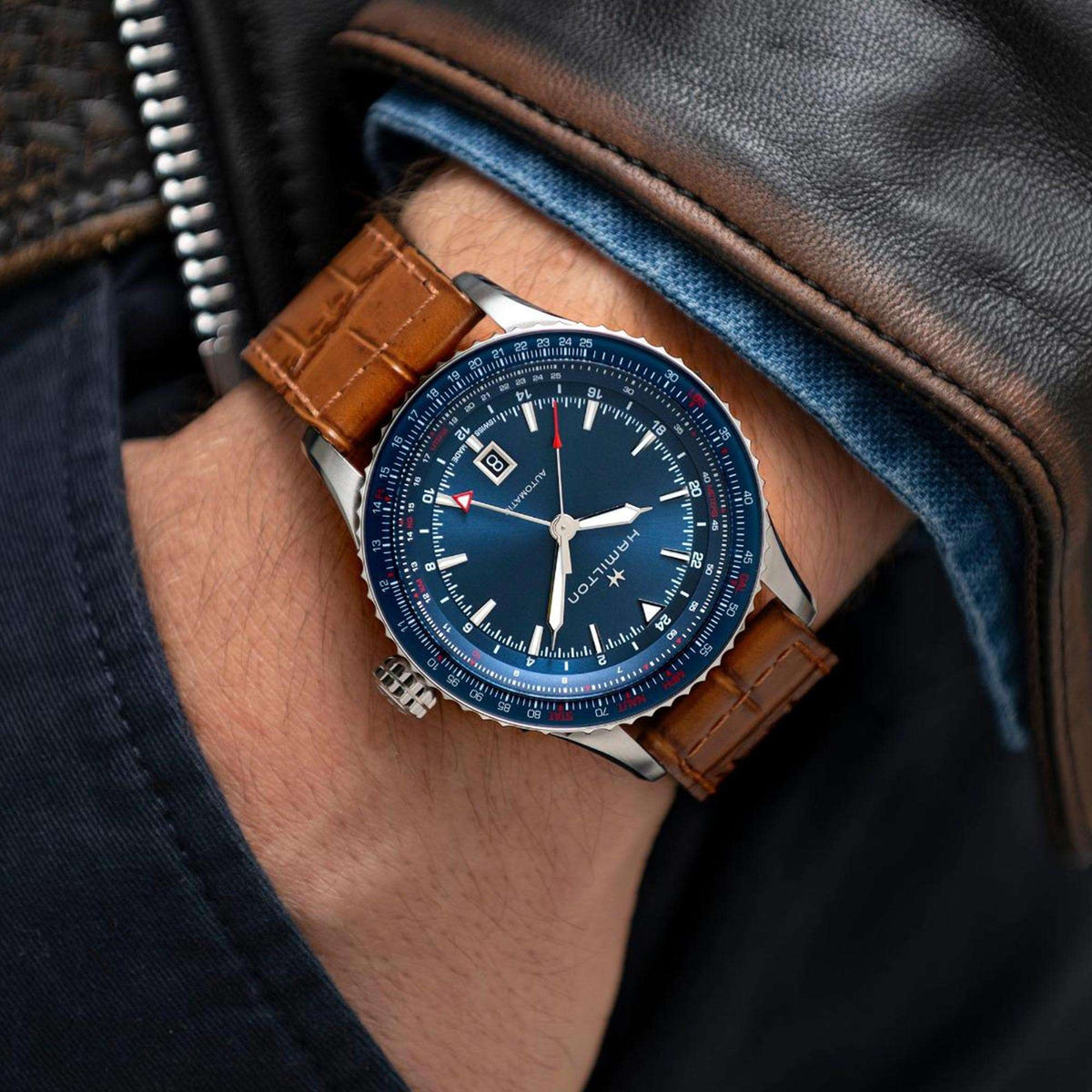 Mens automatic GMT watch on wrist, blue dial and brown leather strap