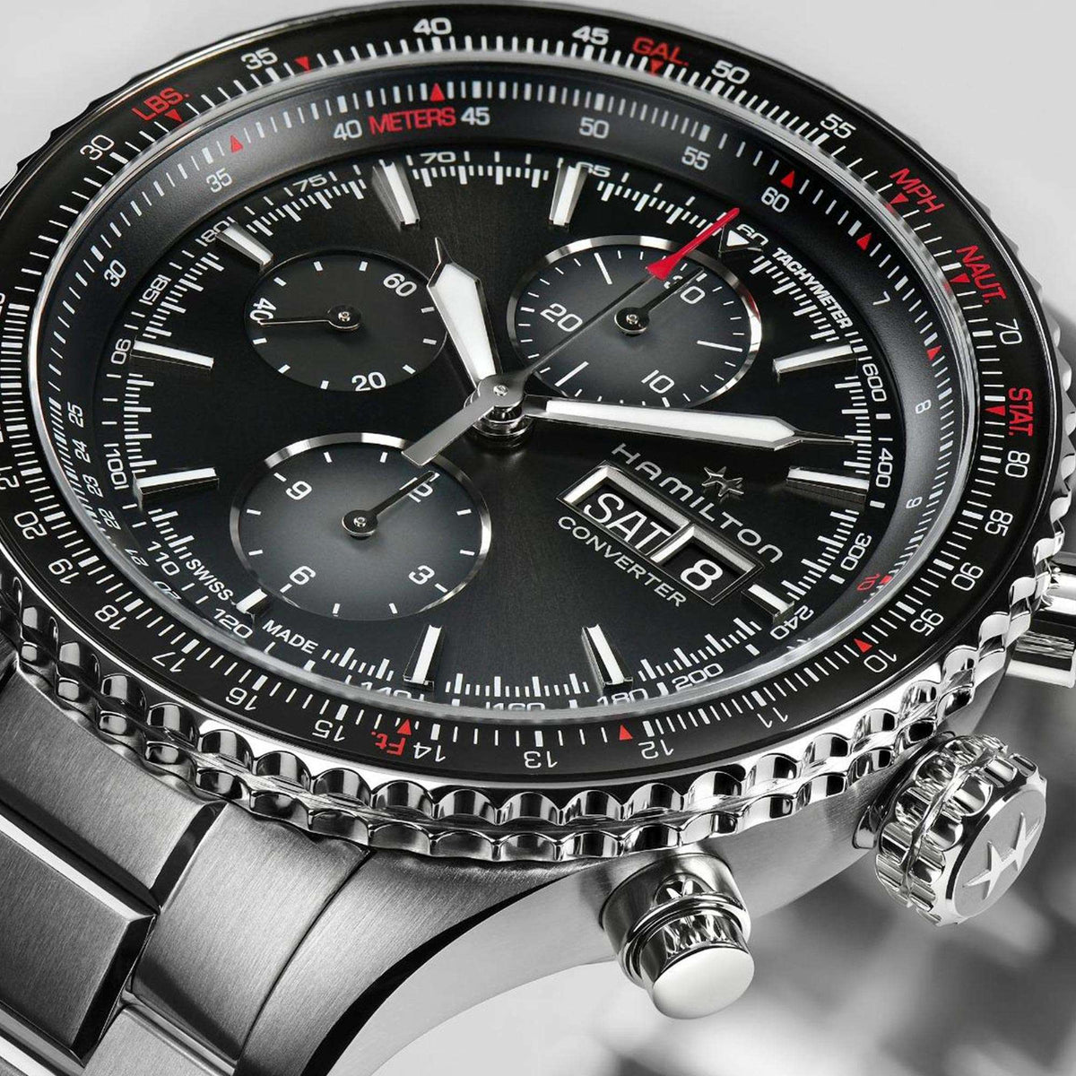 Close-up stainless steel chronograph watch with black dial, silver hands, red minute track.