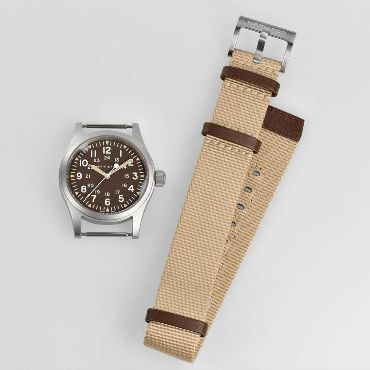 Men’s mechanical field watch and strap details, dark brown dial, tan NATO strap with buckle.