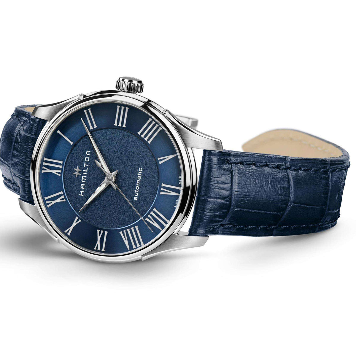 Men's automatic wristwatch angled view: blue dial, Roman numerals, and blue leather strap.