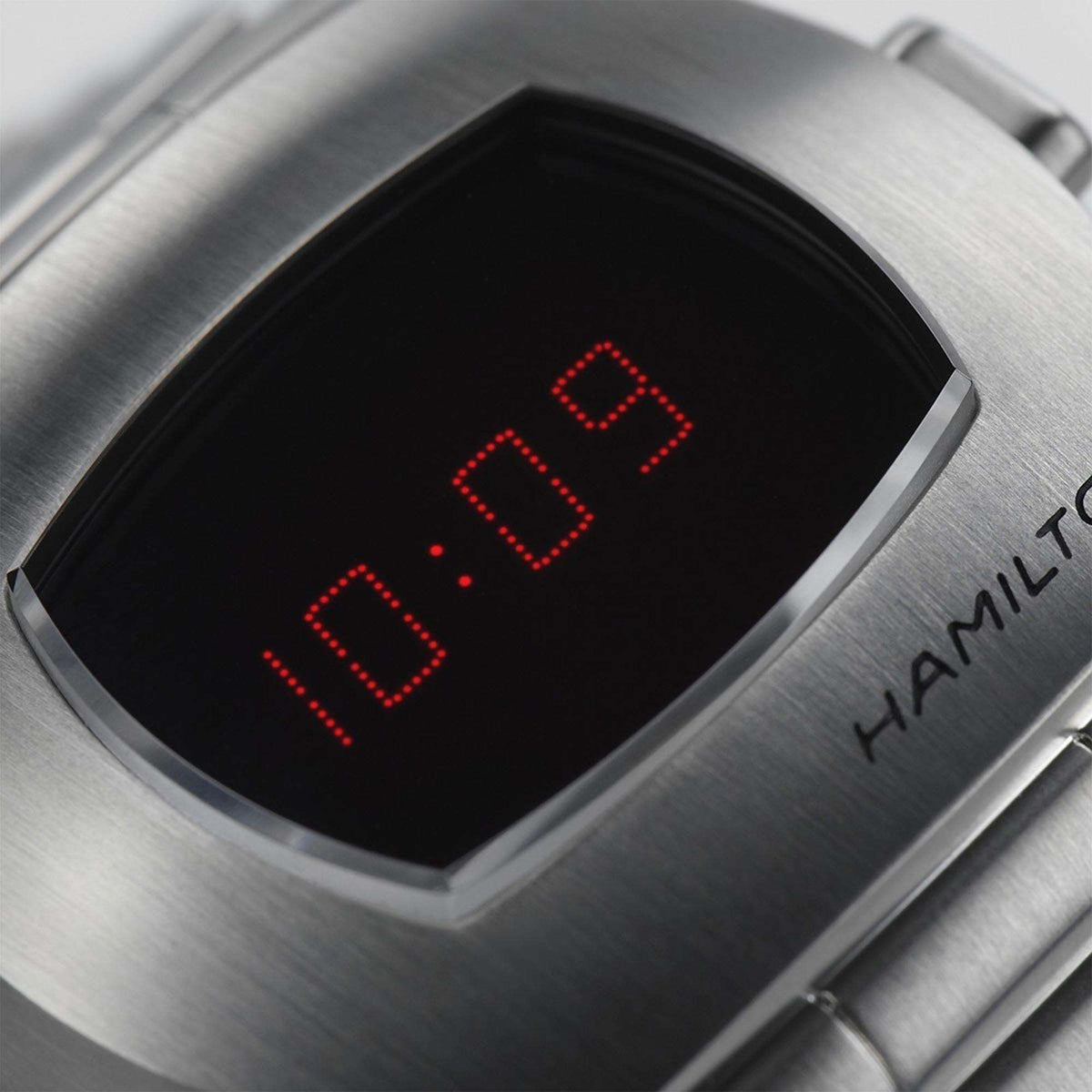 Close-up of a stainless steel Hamilton PSR digital watch with a red LED display.
