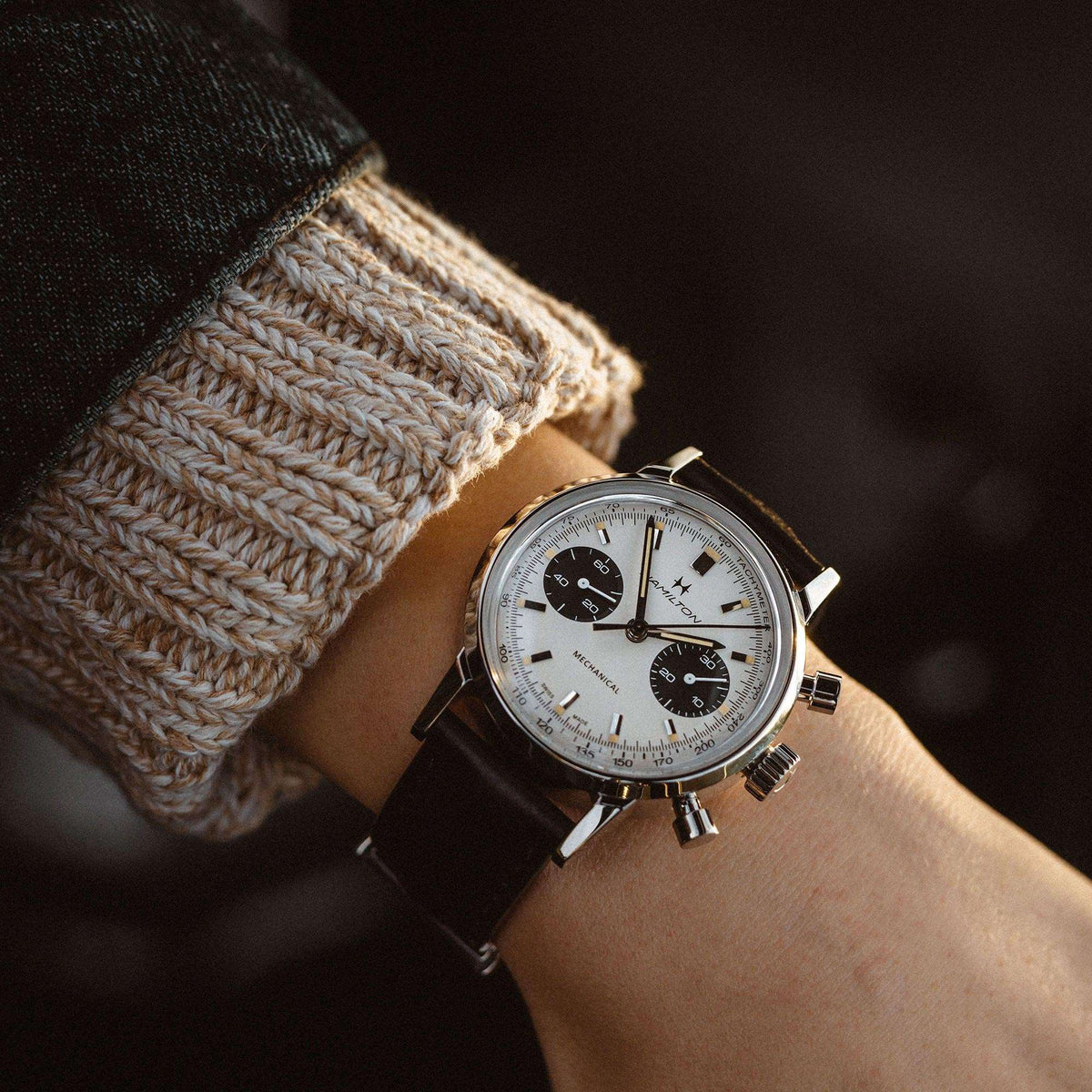 Hamilton chronograph watch on wrist with white dial, black subdials, black leather strap