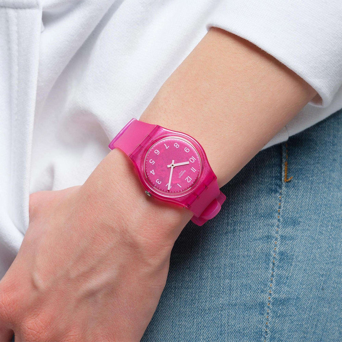Pink dial watch on wrist with white hour markers and pink silicone strap